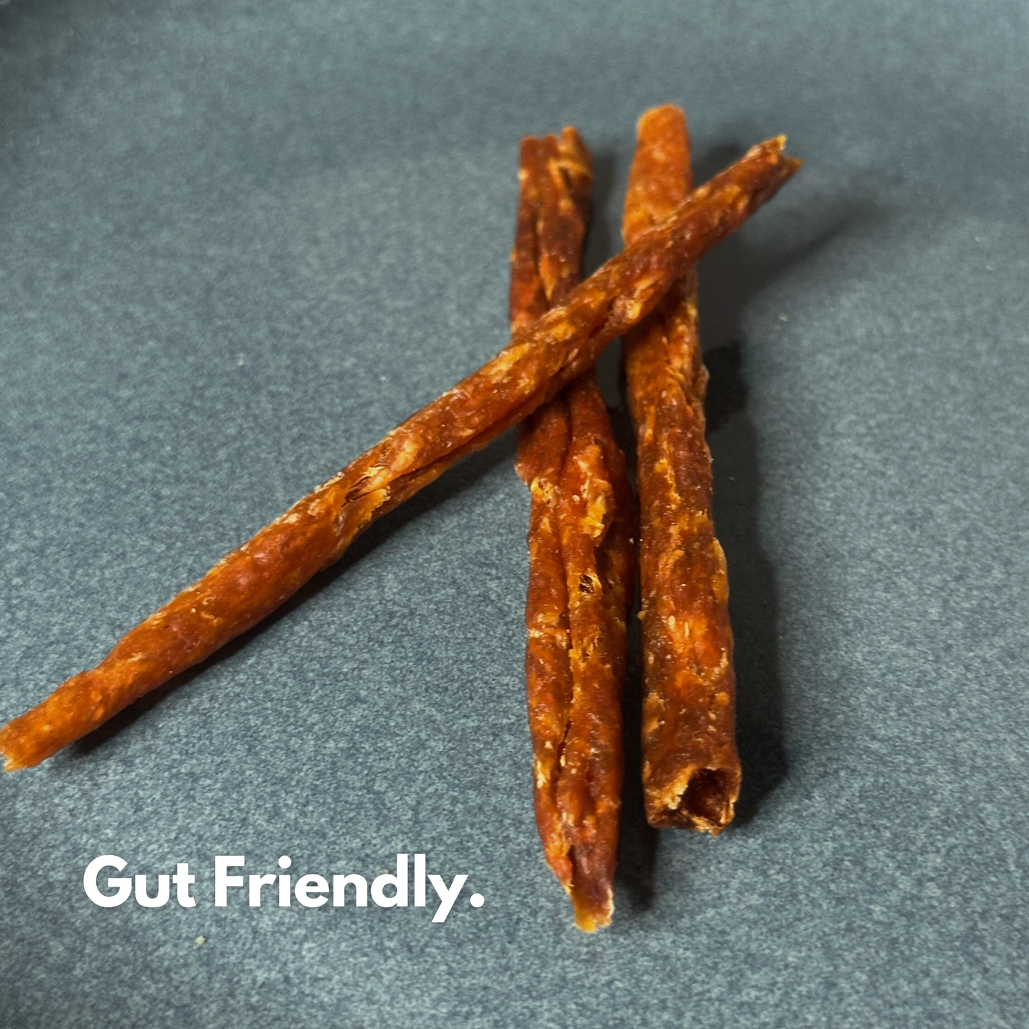 Three 3nhalf dehydrated chicken & pumpkin dog treat sticks labeled as gut-friendly.